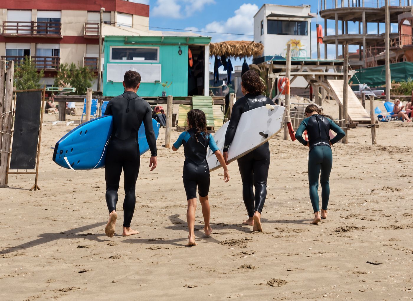 Profes y chicos caminando con sus tablas hacia el mar